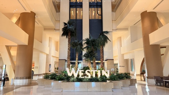 WESTINロゴとヤシの木があるウェスティン リゾート グアムのロビー