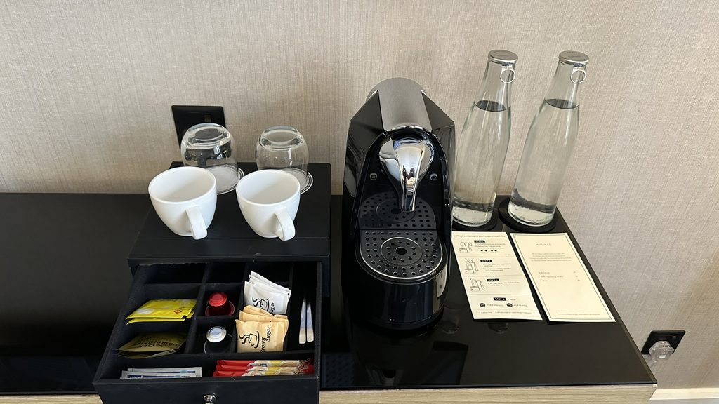 客室のコーヒーマシン、カップ、飲料水とティーバッグ