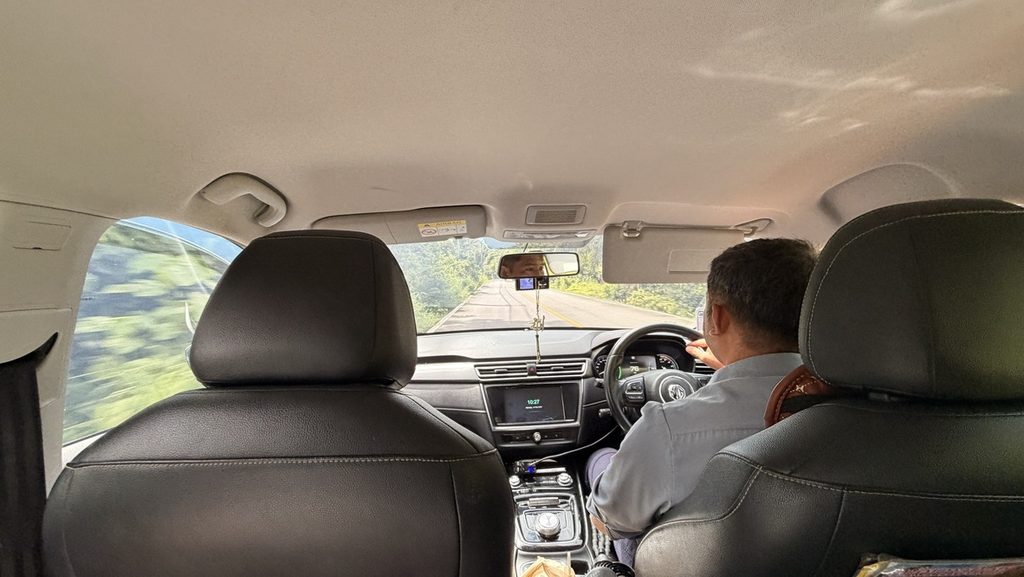 緑の多い道を走るGrabの車内