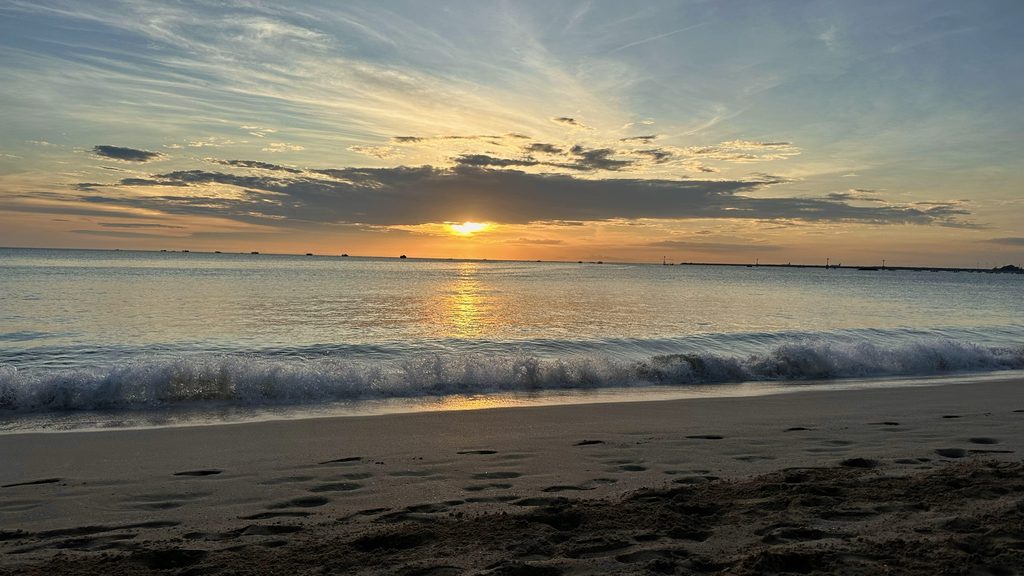 水平線へ沈むジンバランビーチの夕日