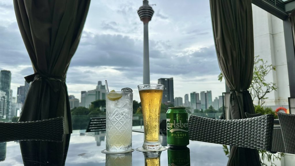 KLタワーを背にテーブルに並ぶモクテルとビール
