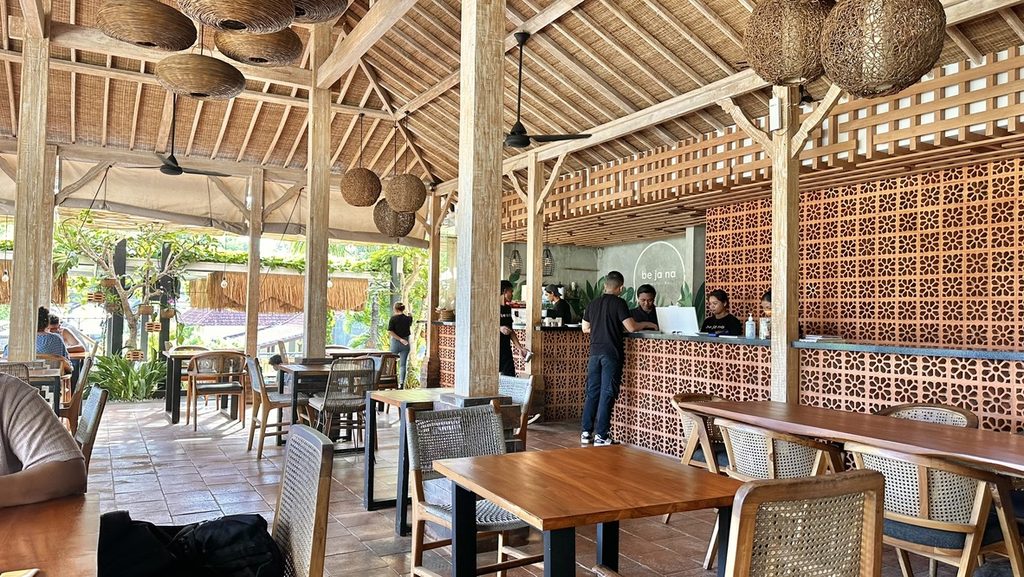 木のテーブルと籐の照明が並ぶWarung Bejana店内