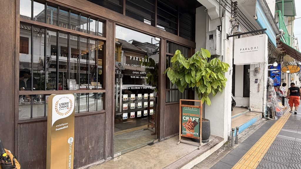 木枠の扉と白い看板があるPARADAiの外観