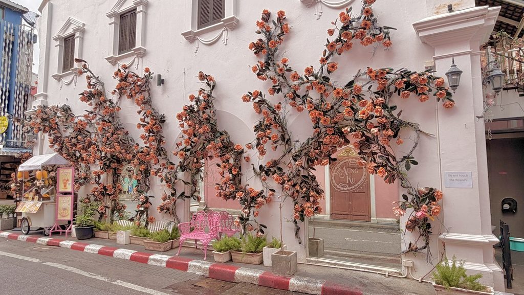 花飾りのあるピンクの建物と同じ色のベンチ