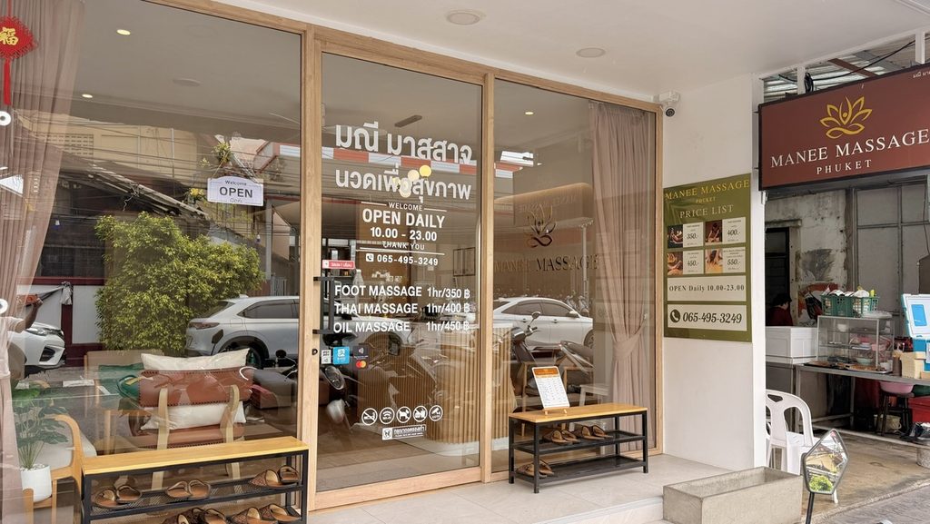 ガラス扉に料金案内があるMANEE MASSAGE PHUKETの入口