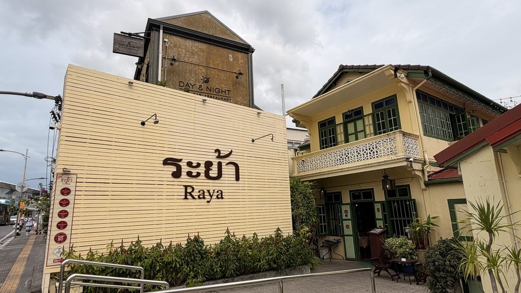 Rayaの看板と緑の窓枠がある淡い黄色の建物