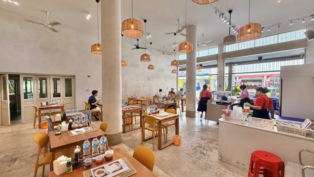 白い壁と高い天井、木のテーブルが並ぶEgg Eggの店内