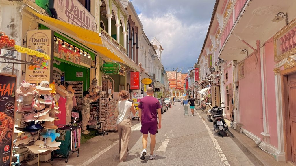 帽子や雑貨を並べた店と、街歩きをする人たち
